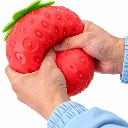 Fresa squishy roja entre dos manos.webp